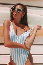 Woman wearing a blue and white striped one-piece swimsuit