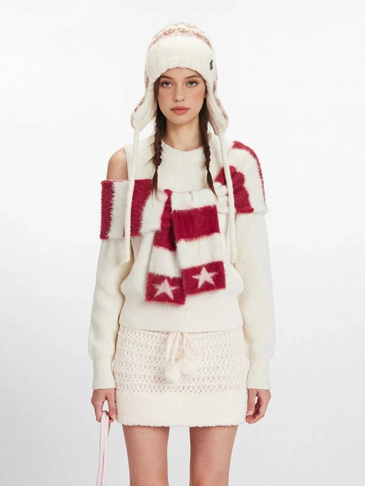 Full body shot of a model in a cream knit outfit, including a sweater, skirt, hat, and scarf.