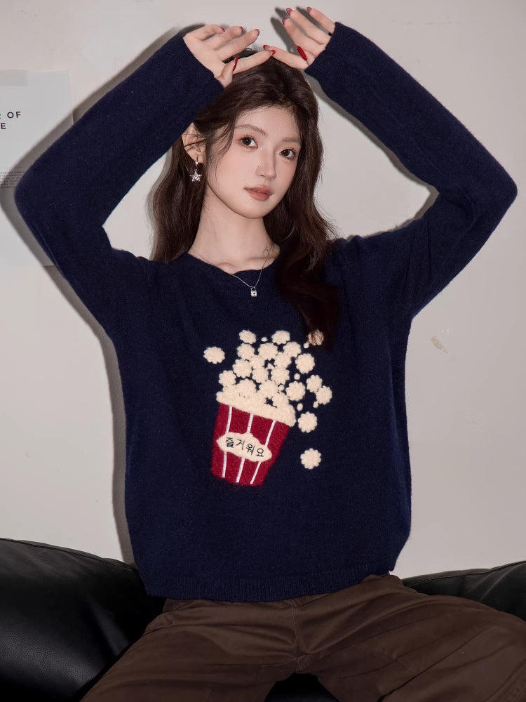 Woman posing with hands raised, wearing a navy blue knit sweater