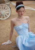 Full shot of a light blue strapless gown displayed on a mannequin against a white background.