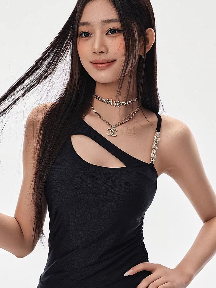 Woman wearing a black one-shoulder dress with a cut-out and tiered skirt