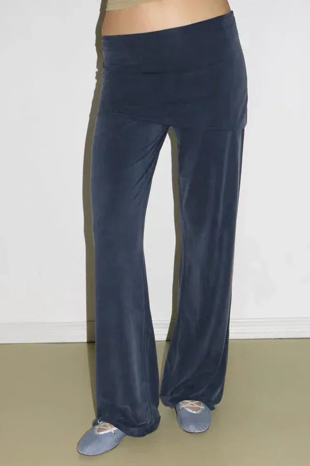 Close-up of navy velour wide leg pants with a flared hem and a high rise elastic waistband.