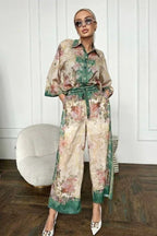 Woman wearing a floral print matching set featuring a button-down shirt and wide-leg pants.