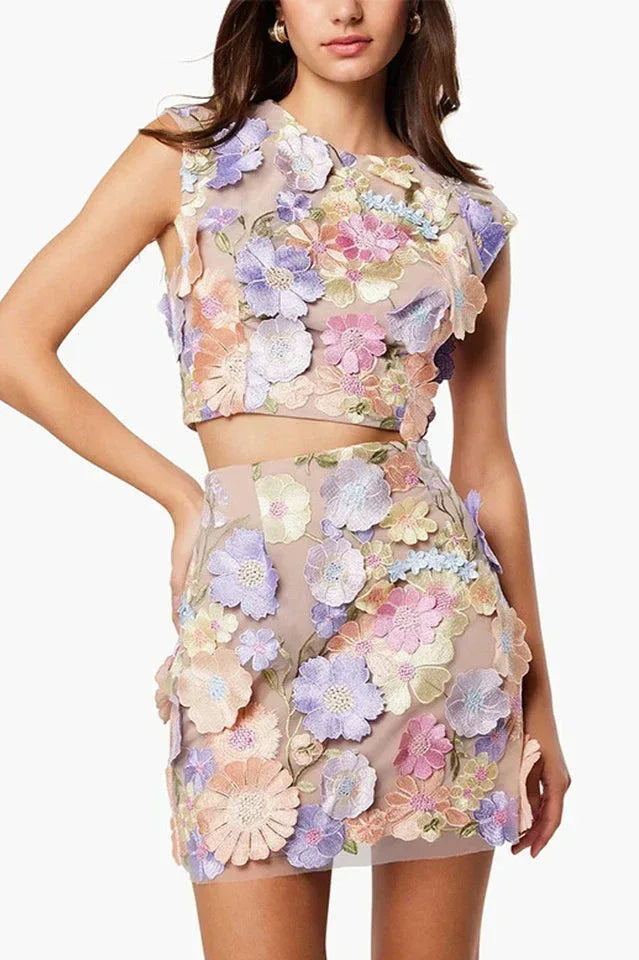 Woman wearing a pastel floral embroidered crop top and mini skirt set Main image