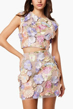 Woman wearing a pastel floral embroidered crop top and mini skirt set