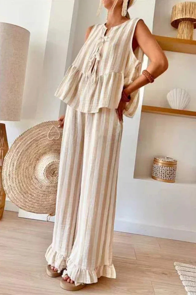 Woman wearing a sleeveless striped peplum top and wide leg pants with ruffled hems