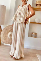 Woman wearing a sleeveless striped peplum top and wide leg pants with ruffled hems