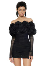 Model showcasing a black off-the-shoulder ruffled mini dress with mesh sleeves