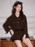 Woman posing in a brown corduroy oversized shirt, highlighting its casual style.
