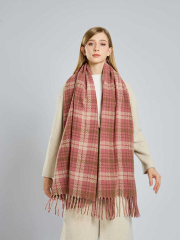 Woman wearing a pink and beige plaid scarf with fringe detail.