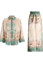 Floral print button-down shirt and wide-leg pants laid flat.