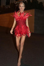 Woman wearing a red sequin and feather mini dress walking outdoors
