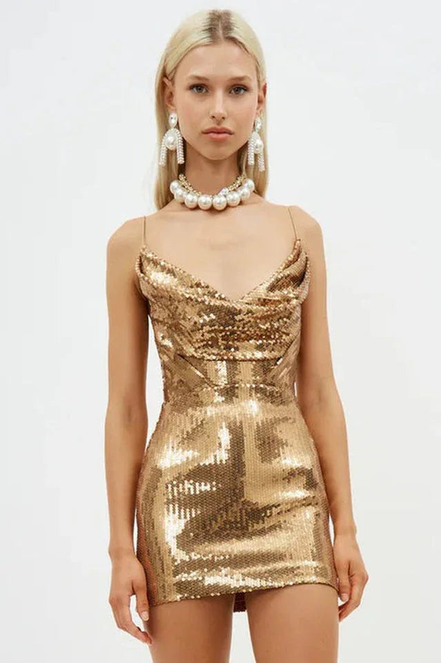 Woman wearing a gold sequined mini dress with a cowl neckline and spaghetti straps.