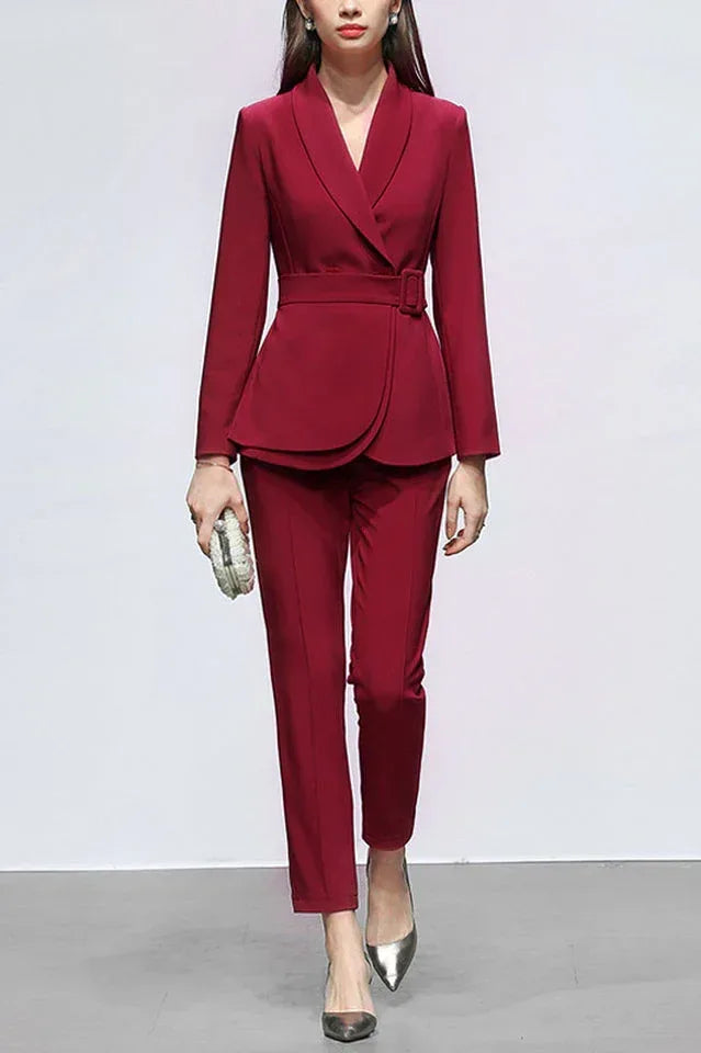 Woman wearing a red double-breasted blazer with a belted waist and peplum hem, paired with matching straight-leg pants. Main image
