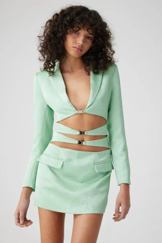 Woman wearing a mint green cut out blazer dress with hardware detail