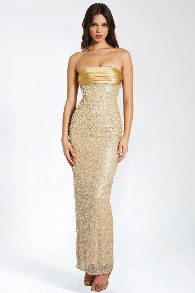 Woman wearing a floor-length gold strapless gown with intricate beading and sequins.