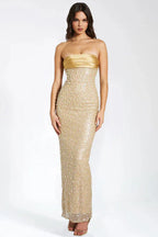 Woman wearing a floor-length gold strapless gown with intricate beading and sequins.