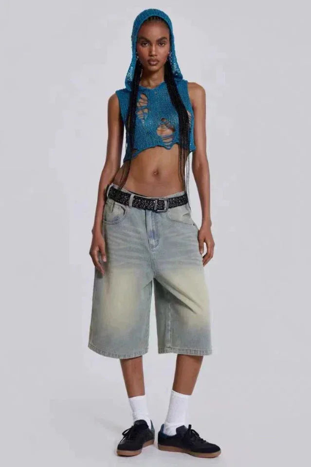 Woman wearing blue distressed knit cropped hooded top and light wash wide leg culottes with black studded belt Main image