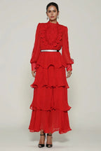 Woman wearing a red tiered chiffon maxi dress with lace detail and balloon sleeves