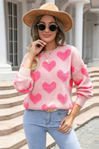Woman wearing a pink heart pattern sweater, fedora hat, and sunglasses.