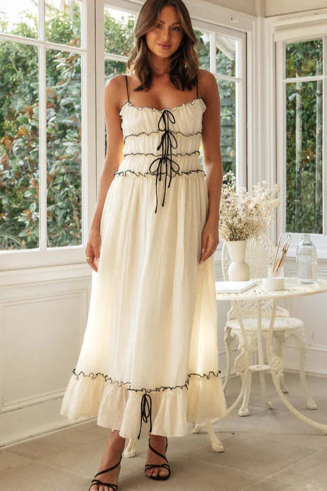 Woman wearing a cream maxi dress with black trim and lace-up detail Main image