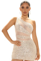 Close-up of a woman in a champagne sequined one-shoulder mini dress with mesh details.