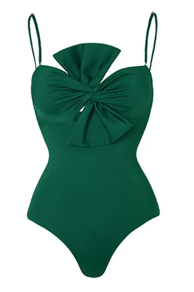 Detail of a green one-piece swimsuit with a bow detail on the bust and thin straps.