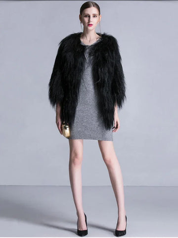 Woman wearing a black faux fur cropped jacket over a grey knit dress