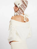 Back view of a white off-the-shoulder cable knit sweater with tie detail