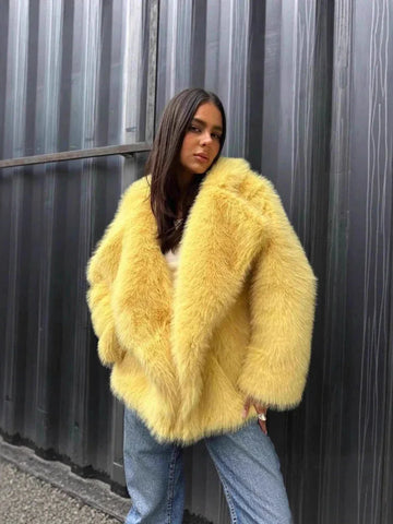 Woman wearing a yellow faux fur jacket and blue jeans