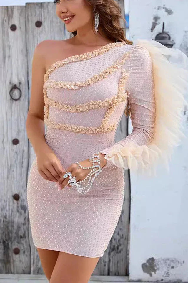 Back view of a woman in a form-fitting, embellished one-shoulder cocktail dress.