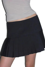 Close-up of a black pleated mini skirt with a high waist and A-line silhouette.
