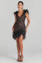 Full-body view of a woman in a black sequined and feathered mini dress, showcasing the sheath silhouette.