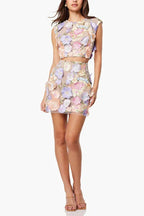 Full body shot of a woman in a pastel floral embroidered two-piece set