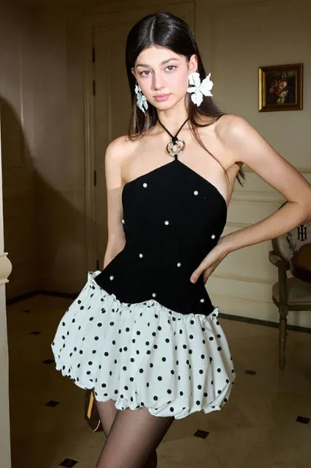Close-up of the fitted bodice and pleated skirt of a grey dress.
