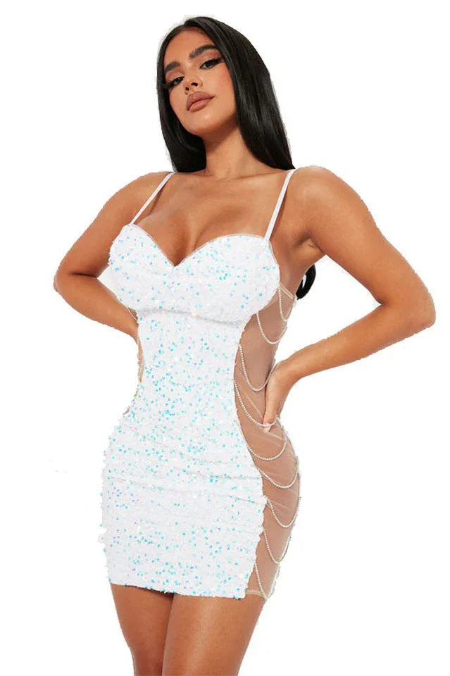 Woman wearing a white sequined mini dress with sheer side panels and chain detail