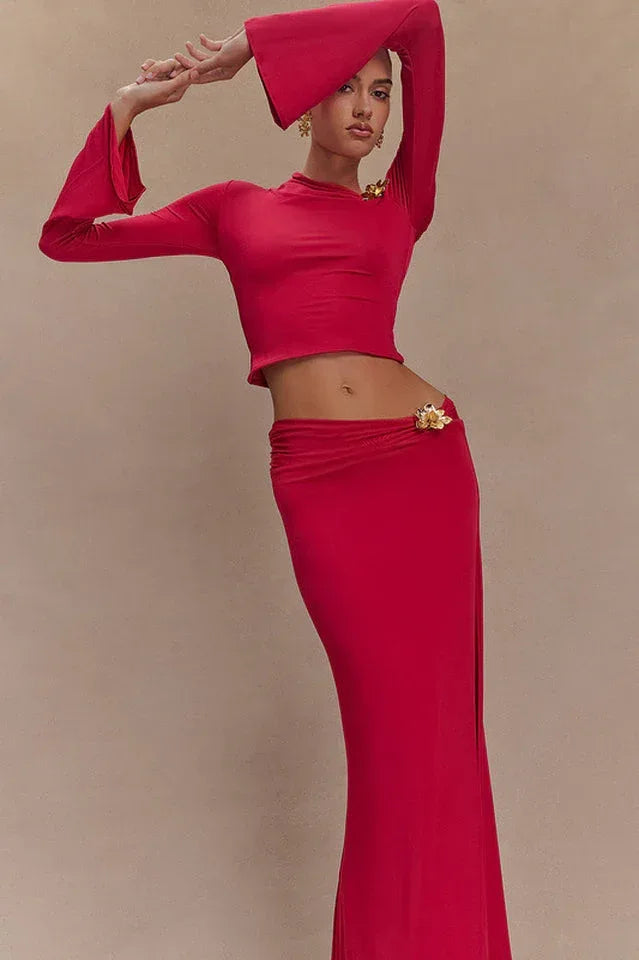 Woman in a red set posing with arms raised, showcasing the flared sleeves and silhouette.