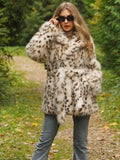 Woman wearing a spotted faux fur coat cinched with a belt