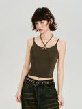 Full body shot of a model wearing a dark olive green halter neck crop top with wide-leg jeans.