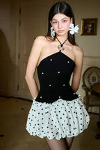 Woman wearing a grey sleeveless dress with a notched lapel collar and button-up front.