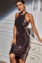 Woman wearing a shimmering, multi-colored sequined halter dress with an open back