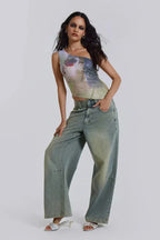 Full-body shot of a woman in a one-shoulder sequined top and wide-leg denim.