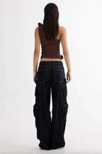 back view of woman in brown one-shoulder ruched top and dark wash wide-leg cargo pants