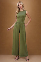 woman wearing a sleeveless wide leg jumpsuit in olive green
