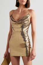 Close-up of a woman wearing a gold sequined mini dress with a cowl neckline.