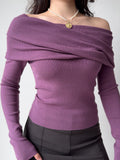 Front view of a woman in a purple off-the-shoulder top and dark skirt.