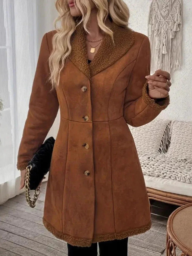 Woman wearing a brown faux suede coat with shearling trim and button-down closure