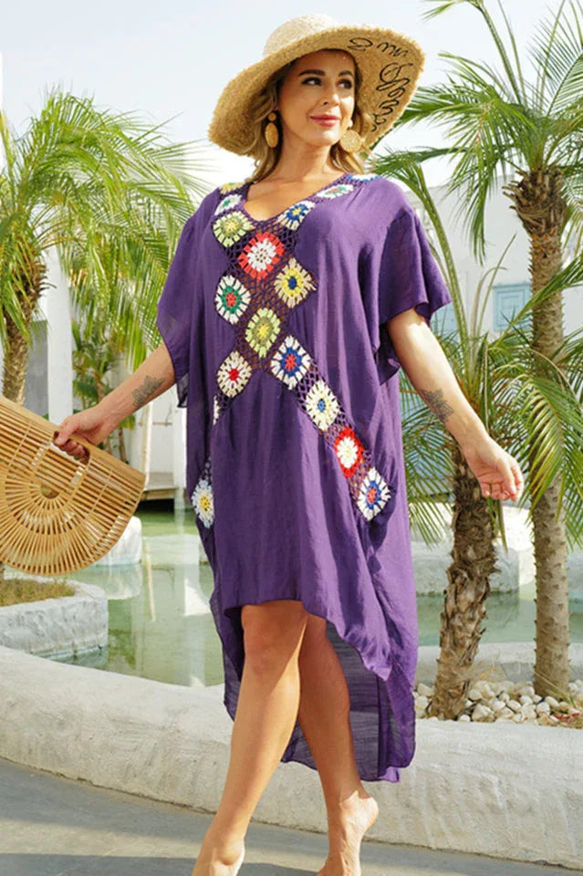 Woman wearing a purple kaftan with crocheted embellishments and a straw hat