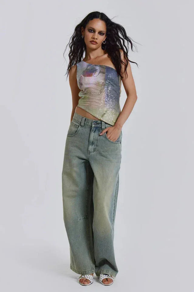 Woman wearing a one-shoulder sequined top with wide-leg jeans.