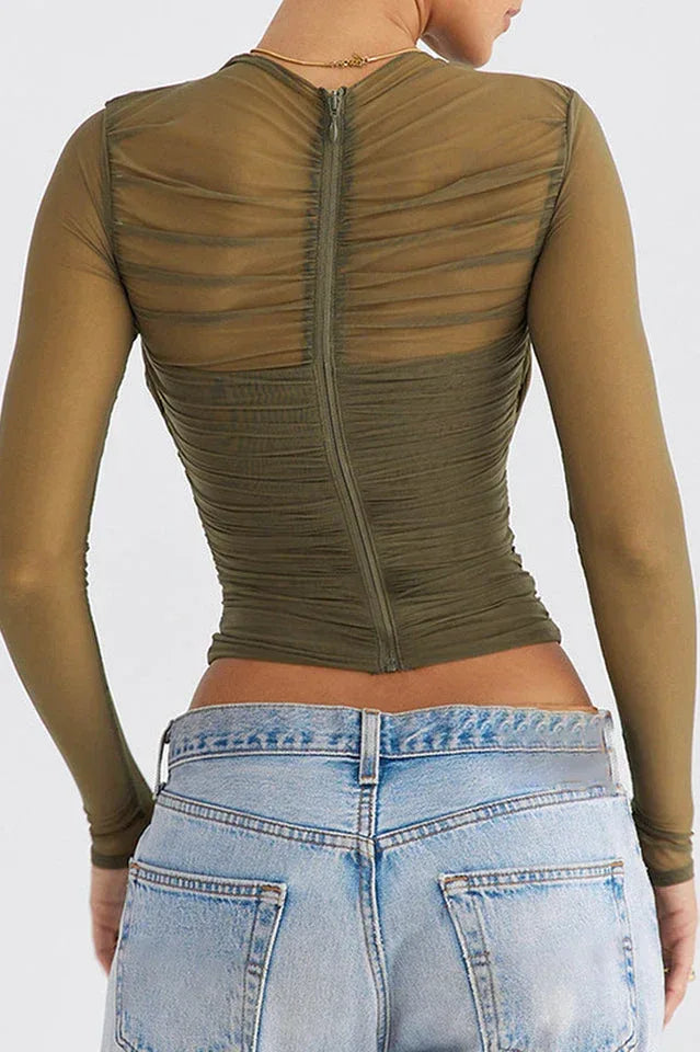 back view of a woman in a ruched mesh top showing zip closure